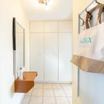 Flur mit Schrank, Spiegel, Telefon und Tasche an der Wand.