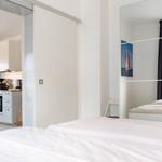 Schlafzimmer mit Blick in die Küche und Spiegelwand.