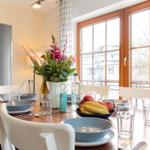 Essbereich mit Tisch, Stühlen und Blick auf Balkon.