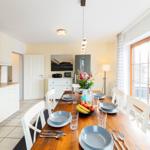 Essbereich mit Holztisch, Stühlen und Fenster zur Terrasse