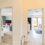 Haus mit Blick in Wohn- und Essbereich mit Küchenzeile und Terrassentür.