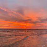 Sonnenuntergang über dem Meer mit Pier im Hintergrund