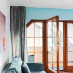 Wohnraum mit Sofa, Fenster und Wandbild