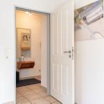 Hausgang mit offener Tür, Wandbild und Spiegelschrank im Hintergrund.