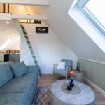 Wohnbereich mit Sofa, Couchtisch und Treppe zur oberen Etage.