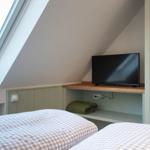 Schlafzimmer mit Dachfenster, TV und Bett