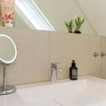 Badezimmer mit Waschbecken, Spiegel und Handseife