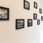 Wand mit mehreren gerahmten Schwarz-Weiß-Fotografien und einem Spiegel im Flur.