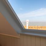 Dachfenster mit Blick auf See und Strand