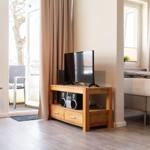 Schlafzimmer mit TV, Bett und Balkonzugang.