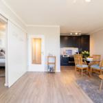 Wohnung mit Schlafzimmer, Küche und Essbereich. Holzboden und moderne Einrichtung.