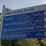 Schild zeigt Entfernungen zu Strand, Museum, Park und Bibliothek.