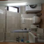 Badezimmer mit Waschmaschine, WC und Badewanne.