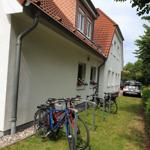 Haus mit rotem Dach, Fahrräder und Grünfläche vorne
