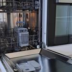 Ein h|tech Spülmaschine mit offener Tür und sichtbaren Körben.