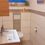 Badezimmer mit Waschbecken, Toilette und Fenster