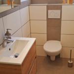 Badezimmer mit Waschbecken, Toilette und Fenster