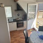 Küche mit Essbereich und Terrasse. Holzdielenboden und Dachschräge.