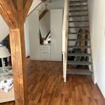 Haus mit Holzfußboden, Treppe und Kleiderschrank unter Dachschrägen.