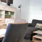 Wohn- und Essbereich mit Sofa, Tisch und Sideboard.