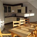 Küche und Essbereich mit Holztisch, Stühlen und Küchenschränken.
