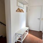 Eingangsbereich mit Hocker, Wandschrank und Holzständer.