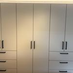 Große weiße Schränke mit schwarzen Griffen und integrierten Lichtern.