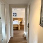 Flur mit Schlafzimmer und Bad. Holzboden und Wandbild.