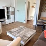 Wohn- und Essbereich mit Sofa, Couchtisch und Fernseher.