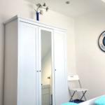 Schlafzimmer mit Kleiderschrank, Wanduhr und Bett