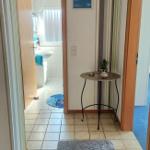 Flur mit Teppich, kleiner Tisch und Blick in Bad und Schlafzimmer.