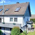 Haus mit Balkon, Garten und Dachfenstern. Außenterrasse mit Gartenmöbeln.