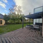 Terrasse mit Sitzgelegenheit und Sauna im Garten