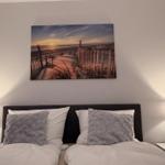 Schlafzimmer mit Bett, zwei Nachttischen und Wandbild an der Wand.