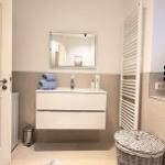 Badezimmer mit Waschbecken, Spiegel und Heizkörper