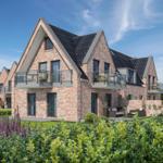 Moderne Ferienwohnung mit Balkonen und Garten. Zwei Stockwerke mit Glasgeländern.