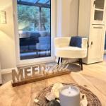 Wohnbereich mit Sitzgelegenheit und Blick auf Terrasse. Dekoration mit Meeresmotiven.