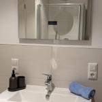 Bad mit Waschbecken, Spiegel und Duschkabine