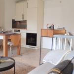 Wohnbereich mit Essbereich und Küche. Sofa, Tisch und Stühle sind sichtbar.