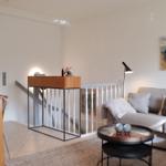 Wohn- und Essbereich mit Sofa, Tisch und Küchenzeile.