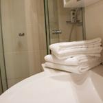 Badezimmer mit Dusche, Waschbecken und Handtüchern.