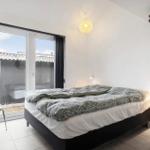 Bedroom with bed, wardrobe, and window to outdoor terrace.