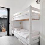 Room with bunk bed, sliding door, and wardrobe.