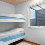 Zimmer mit Doppelstockbett und Fenster zur Außenseite.