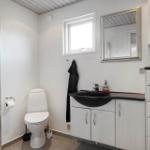 Badezimmer mit Dusche, Toilette und Waschbecken mit Spiegel.