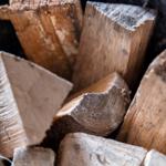 Sichtbar sind geräumte Holzscheite in einem Korb.