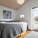 Schlafzimmer mit Bett, Decke und Tür zu einer Terrasse.