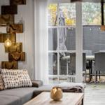 Wohnbereich mit Sofa und Blick auf Terrasse mit Tisch und Stühlen.