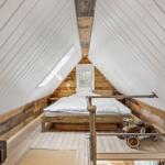 Schlafzimmer mit Dachschrägen, Bett und Kinderwagen