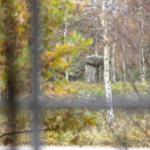 Durch Bäume gesehen: Steinmonument im Herbstwald.